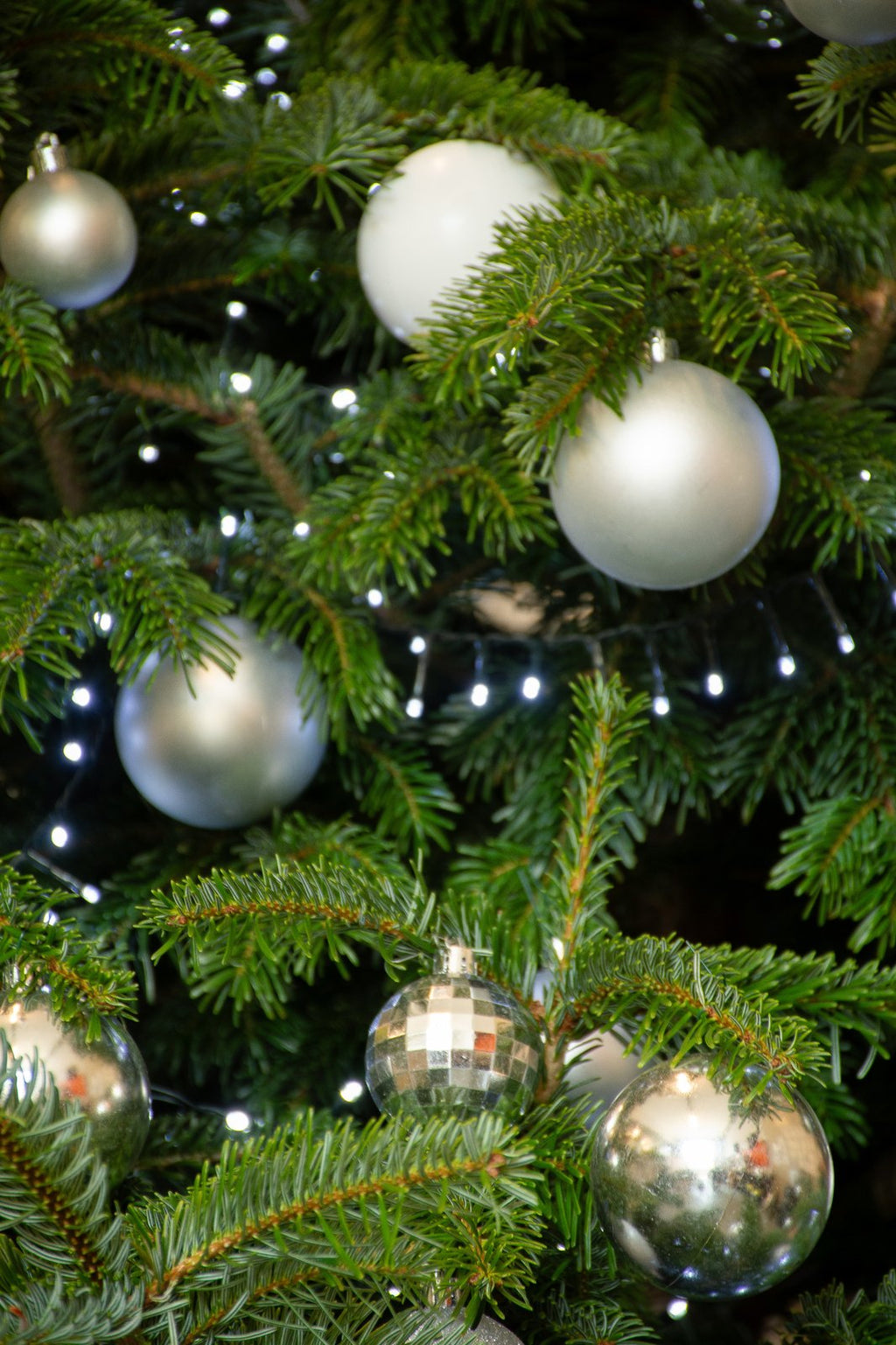 Détail des boules argent et blanc sur un sapin décoré par Sapin & Go